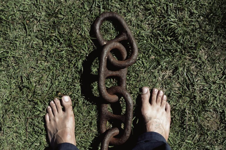 La partie inferieure de l homme debout sur l herbe par la chaine